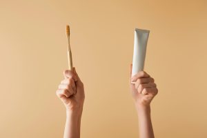 toothbrush in one fist toothpaste tub in the other
