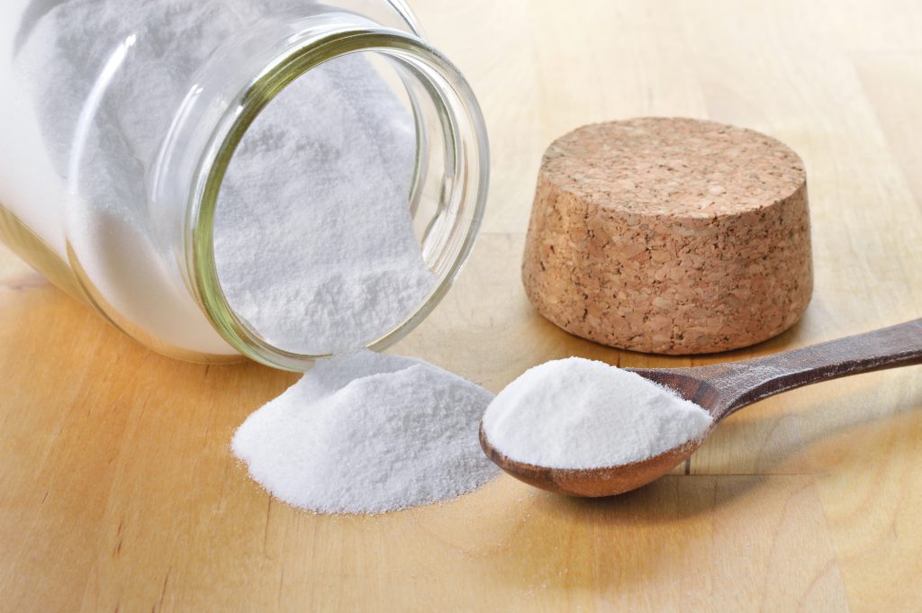 tipped over jar of baking soda and baking soda in spoon